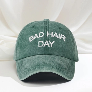 Washed green cotton baseball cap with white 3D BAD HAIR DAY embroidery on white silk background