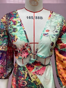 Detail of bohemian landscape print dress featuring V-neck and waist cut-out with metal ring