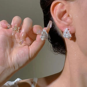 Macro view of multi-layered C-shaped silver earrings with pink zircon and small pearls