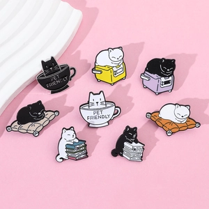 Collection of eight cute cartoon cat enamel pins in various poses on pink background