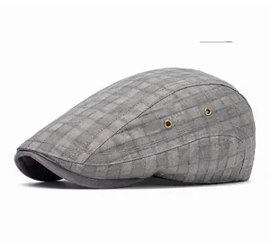 Close-up of gray plaid flat cap showing bronze ventilation eyelets and fabric texture