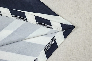 Macro detail of overlock stitch finishing on black and white striped V-neck long dress