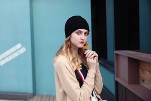 Close-up of black knit beanie texture and ribbed cuff worn by female model outdoors