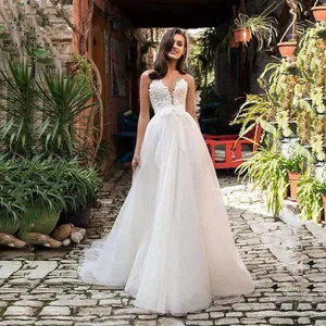 Detail of white bridal gown featuring delicate 3D floral lace appliques and tulle skirt