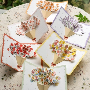 Set of 3D pop-up flower bouquet cards including carnations and tulips on linen