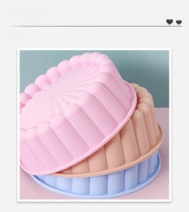 Detailed view of round wavy silicone cake molds in pink, brown and blue colors