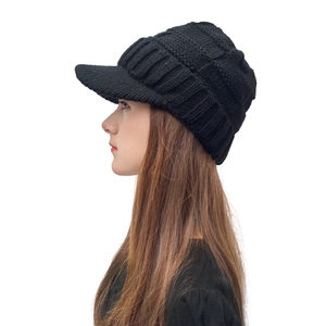 Gros plan d'un bonnet à visière en maille noire avec texture épaisse et bord rigide