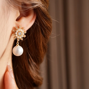 Gros plan sur boucles d'oreilles flocon avec zircons et perle sur le mannequin