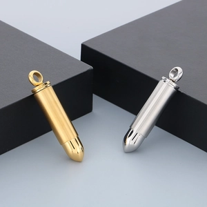 Close-up of minimalist gold and silver bullet pendants on black cubic stands