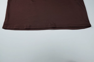 Détail de l'ourlet à double couture sur une robe à manches longues marron foncé