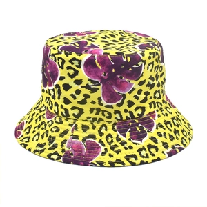 Detailed view of yellow leopard print bucket hat with purple tropical leaf patterns