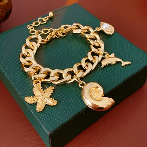 Detailed shot of golden chunky chain bracelet featuring ocean charms and pearl accent