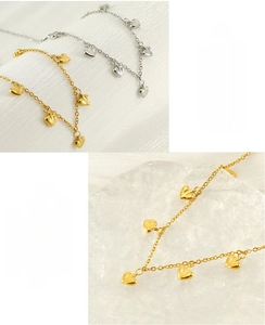 Detail of heart pendant necklaces in gold and silver finish with high polish texture