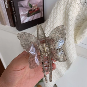 Detail showing taupe butterfly hair claw with marble texture and handmade engraving