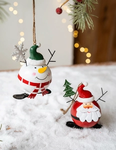 Detailed view of metal snowman and Santa ornaments in festive snowy scenery