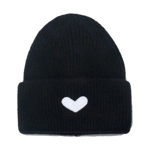 Detail shot of the black ribbed knit beanie featuring a white embroidered heart design