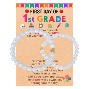 Detail of two crystal beaded bracelets with gold hearts on a back-to-school card
