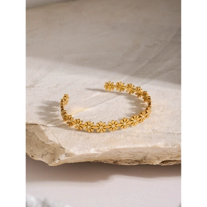 18k gold plated stainless steel daisy cuff bracelet with pearls on a white stone background