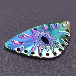 Detailed macro view of an iridescent stainless steel eye-shaped charm with ornate engravings