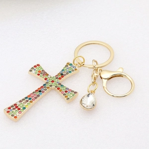 Detail of golden cross keychain with colorful rhinestones and teardrop crystal pendant