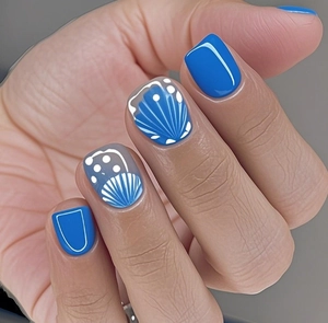 Detailed view of Klein blue and white seashell style press-on nails with wave patterns