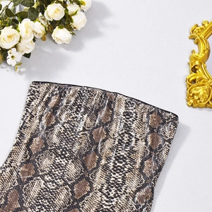 Détail du tissu à paillettes motif serpent avec fleurs élégantes et miroir vintage décoratif