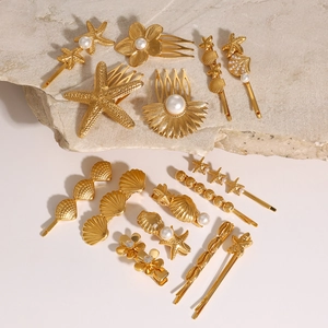 Golden starfish and shell hair clips set with pearls on a natural stone background