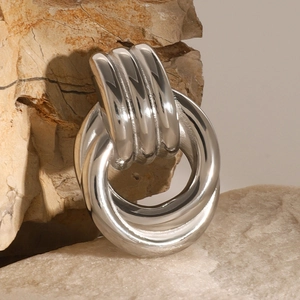 Close-up of triple interlocking silver rings on a rustic stone background