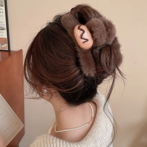 Detailed close-up of brown flocked acrylic hair claw clip with cute biscuit decoration