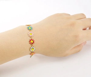 Detailed close-up of 18K gold-plated bracelet with multi-colored enamel daisy charms