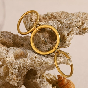 Macro shot of 18K gold plated triple layered ring set on natural stone surface