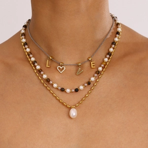 Dettaglio della collana a strati in acciaio inossidabile con perle e pendente LOVE