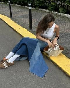 Outdoor street shot of patchwork denim skirt with frayed hem and irregular waist