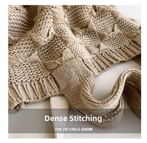 Detail of chunky knit fabric featuring decorative bow pattern and ribbed edges