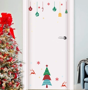 Christmas door stickers with reindeer and tree decals on a white door in a festive room