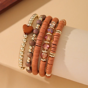 Detail view of five-piece Bohemian bracelet set with gold beads and clay discs