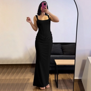 Detail showing corset-style boning and side ruching on a black bodycon maxi dress