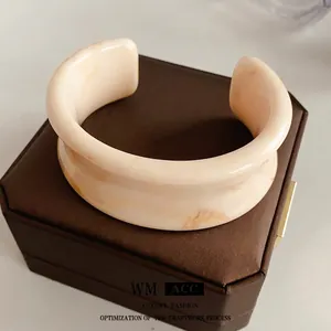 Minimalist wide open resin bangle featuring brown marble texture on a jewelry box