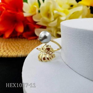 Golden monstera leaf open ring with a grey shell pearl on a bright modern background