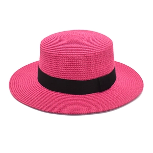 Close-up of fuchsia boater straw hat with black grosgrain ribbon and fine texture