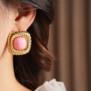 Details von quadratischen Vintage-Goldohrringen mit einem rosa Edelstein in der Mitte