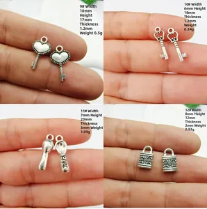 Vue macro de quatre breloques argent antique incluant clé, couronne, cadenas et cuillère