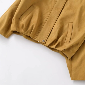 Cropped view of mustard yellow suede bomber jacket featuring metal snap button and pocket