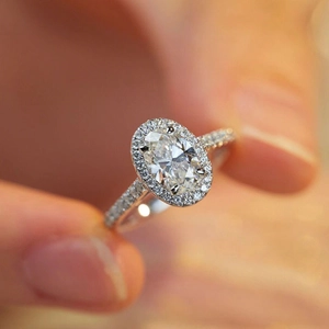 Detailed macro view of an oval cut zircon ring with micro-paved stones in white gold finish