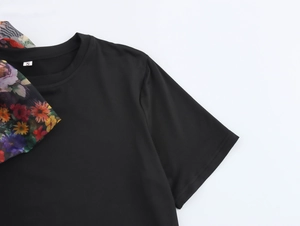 Detail view of black round neck T-shirt featuring floral organza ribbon and size S tag