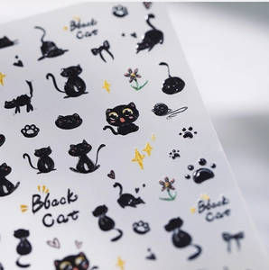 Macro view of 3D embossed black cat nail stickers with stars and floral details