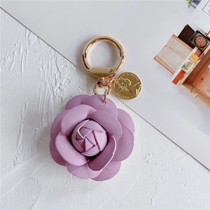 Detail of purple leather camellia flower keychain with golden coin charm and ring