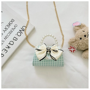 Dettaglio mini borsa pied-de-poule verde menta con manico di perle e fiocco con camelia