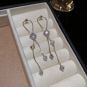 Vue macro de boucles d'oreilles pendantes en argent avec zircone et chaîne élégante