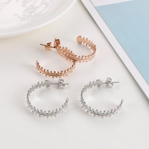 Macro view of C-shaped fishbone hollow earrings in rose gold and silver finishes
